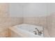 Bright bathroom with a tiled bathtub and decorative chrome fixtures at 1591 Chestnut W Ct, Palm Harbor, FL 34683