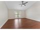 Spacious bedroom with hardwood floors, ceiling fan, and a large window at 1591 Chestnut W Ct, Palm Harbor, FL 34683