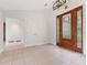 Bright foyer featuring tile flooring, decorative wood door with glass, and two entries to rooms on either side at 1591 Chestnut W Ct, Palm Harbor, FL 34683