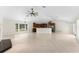 Open-concept great room with kitchen featuring tile flooring, high ceilings, neutral tones, and natural light at 1591 Chestnut W Ct, Palm Harbor, FL 34683