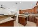Kitchen showcasing granite countertops, tile backsplash, and a center island with a gas cooktop at 1591 Chestnut W Ct, Palm Harbor, FL 34683
