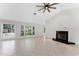Spacious living room with vaulted ceilings, fireplace, tile flooring, and bright natural light from the windows at 1591 Chestnut W Ct, Palm Harbor, FL 34683