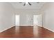Large living room with three doorways, hardwood floors, and a ceiling fan at 1591 Chestnut W Ct, Palm Harbor, FL 34683