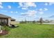 Spacious backyard featuring a tranquil pond view, lush green grass, and comfortable lounge chairs for outdoor relaxation at 17923 Cantarina Cv, Bradenton, FL 34211
