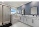 Luxurious bathroom featuring double vanity sinks, a bathtub, and a separate glass shower at 17923 Cantarina Cv, Bradenton, FL 34211