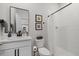 Modern bathroom featuring a vanity with a sink, toilet, and walk-in shower with a curtain at 17923 Cantarina Cv, Bradenton, FL 34211