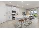 Modern kitchen featuring white cabinets, an island with barstool seating, stainless steel appliances, and tile flooring at 17923 Cantarina Cv, Bradenton, FL 34211