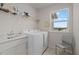 Bright laundry room features white washer and dryer with sink and window at 17923 Cantarina Cv, Bradenton, FL 34211