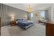 Stylish main bedroom with decorative accent wall, modern chandelier, and scenic outdoor views at 17923 Cantarina Cv, Bradenton, FL 34211