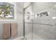 Bright bathroom featuring a modern marble shower, a window and neutral colored towels hanging nearby at 1827 Venetian Point Dr, Clearwater, FL 33755
