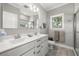 Bright bathroom featuring a double vanity with a modern sink, a large mirror and a marble walk-in shower at 1827 Venetian Point Dr, Clearwater, FL 33755