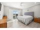 Well-lit bedroom with wood floors, modern ceiling fan, and sleek, gray headboard at 1827 Venetian Point Dr, Clearwater, FL 33755