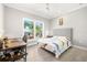 Bedroom featuring wood floors, ceiling fan and view of neighborhood from large window at 1827 Venetian Point Dr, Clearwater, FL 33755