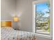 Bright bedroom featuring a comfy bed, bedside lamp, and a large window with views of the outdoors at 1827 Venetian Point Dr, Clearwater, FL 33755