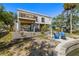 Rear exterior featuring raised construction, a manicured lawn, and blue furniture, creating an inviting outdoor space at 1827 Venetian Point Dr, Clearwater, FL 33755
