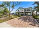 Charming two-story elevated home featuring a brick driveway and well-maintained landscaping at 1827 Venetian Point Dr, Clearwater, FL 33755