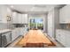 Bright kitchen with white cabinets and stainless steel appliances, with an adjacent dining table at 1827 Venetian Point Dr, Clearwater, FL 33755