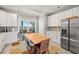 Eat-in kitchen with white cabinetry, stainless steel appliances, and a large dining table at 1827 Venetian Point Dr, Clearwater, FL 33755