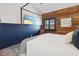 Comfortable bedroom featuring a four-poster bed and wood paneled accent wall at 19727 Gulf Blvd # 207, Indian Shores, FL 33785