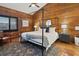 Beautiful bedroom boasting wood paneled walls, four poster bed, and rustic decor at 19727 Gulf Blvd # 207, Indian Shores, FL 33785