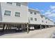Multi-level condos on stilts, featuring covered parking, and providing a glimpse of the surrounding landscape at 19727 Gulf Blvd # 207, Indian Shores, FL 33785