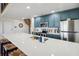 Well-appointed kitchen with stainless steel appliances, blue cabinets, and a large island with seating, perfect for cooking at 19727 Gulf Blvd # 207, Indian Shores, FL 33785