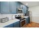 Modern kitchen with stainless steel appliances, quartz countertops, and custom blue cabinets, combining style and functionality at 19727 Gulf Blvd # 207, Indian Shores, FL 33785