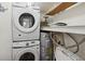 A laundry room that features a stacked washer and dryer with an A. O. Smith water heater at 19727 Gulf Blvd # 207, Indian Shores, FL 33785
