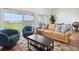 Bright living room featuring comfortable seating, a large window with a view, and stylish decor at 19727 Gulf Blvd # 207, Indian Shores, FL 33785