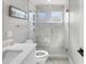 Clean bathroom features stand-up shower with glass door and white marble tile at 200 98Th Ne Ave, St Petersburg, FL 33702