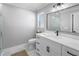 Modern bathroom with marble floors, a single sink vanity, a large mirror, and a glass shower at 200 98Th Ne Ave, St Petersburg, FL 33702