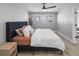 Comfortable bedroom features a large window, ceiling fan, and a stylish upholstered headboard at 200 98Th Ne Ave, St Petersburg, FL 33702