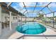 A clear in-ground pool with a covered lanai, columns, table and chairs and a glimpse of the canal at 200 98Th Ne Ave, St Petersburg, FL 33702