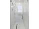 Sleek, all-white shower with a glass door, tiled walls, and convenient built-in storage niches at 200 98Th Ne Ave, St Petersburg, FL 33702