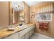 Elegant bathroom featuring a white vanity with marble countertop and decorative fixtures at 2029 Winding Oaks Dr, Palm Harbor, FL 34683