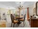 Traditional dining room with a round wooden table, chandelier, and view into the kitchen at 2029 Winding Oaks Dr, Palm Harbor, FL 34683