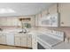 Well-lit kitchen features white appliances, ample counter space, and natural light at 2029 Winding Oaks Dr, Palm Harbor, FL 34683