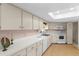 Bright kitchen with white cabinets, a skylight, and modern appliances at 2029 Winding Oaks Dr, Palm Harbor, FL 34683