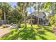 Beautiful backyard featuring a fire pit, seating, lush lawn, landscaping, and a deck at 224 Ontario Ave, Crystal Beach, FL 34681