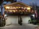 Charming two-story home with a large deck, accented by string lights and well-maintained landscaping at 224 Ontario Ave, Crystal Beach, FL 34681