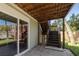 Covered patio area with steps leading to the backyard and sliding glass doors to the home at 224 Ontario Ave, Crystal Beach, FL 34681