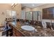 Large bathroom featuring double vanity, marble countertop, dark wood cabinets, and frameless glass shower at 2630 Grand Lakeside Dr, Palm Harbor, FL 34684