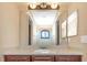 Bathroom with granite countertop, dark wood cabinets, mirror reflecting tiled shower at 2630 Grand Lakeside Dr, Palm Harbor, FL 34684