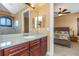 Bathroom vanity with sink and dark wood cabinets, next to a bedroom and toilet at 2630 Grand Lakeside Dr, Palm Harbor, FL 34684