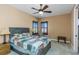 This bedroom features a patchwork quilt on the bed, shuttered windows, ceiling fan, and a rocking chair at 2630 Grand Lakeside Dr, Palm Harbor, FL 34684