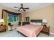 Bedroom with neutral walls, a ceiling fan, and windows adorned with decorative curtains at 2630 Grand Lakeside Dr, Palm Harbor, FL 34684