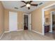 Bedroom with carpet flooring, ceiling fan, walk-in closet and an attached bathroom at 2630 Grand Lakeside Dr, Palm Harbor, FL 34684
