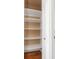 An organized closet with white shelves and wood floors with door ajar at 2630 Grand Lakeside Dr, Palm Harbor, FL 34684