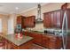 Gourmet kitchen features dark wood cabinets, granite countertops, stainless steel appliances, and a center island at 2630 Grand Lakeside Dr, Palm Harbor, FL 34684