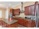 Gourmet kitchen features dark wood cabinets, granite countertops, stainless steel appliances, and a center island at 2630 Grand Lakeside Dr, Palm Harbor, FL 34684